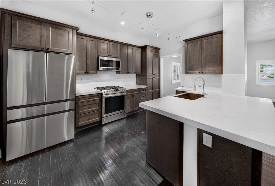 1740 Bluffs Drive, Henderson, NV 89014 Rich wood cabinetry contrasts beautifully with clean stone countertops and professional stainless steel appliances.