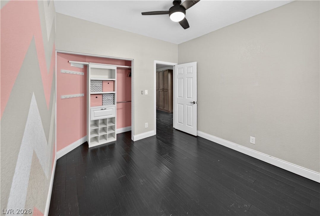 1740 Bluffs Drive, Henderson, NV 89014 Rich dark wood flooring anchors this versatile space featuring custom closet organization.