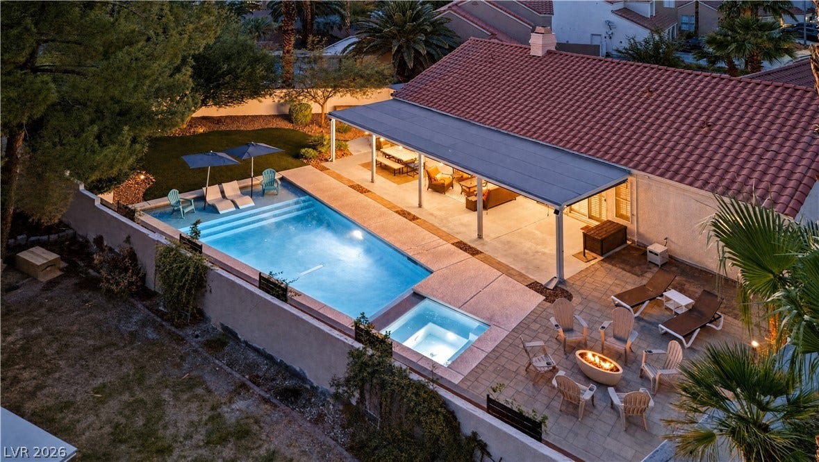 1740 Bluffs Drive, Henderson, NV 89014 An inviting backyard oasis features a shimmering pool alongside a generous covered patio structure.