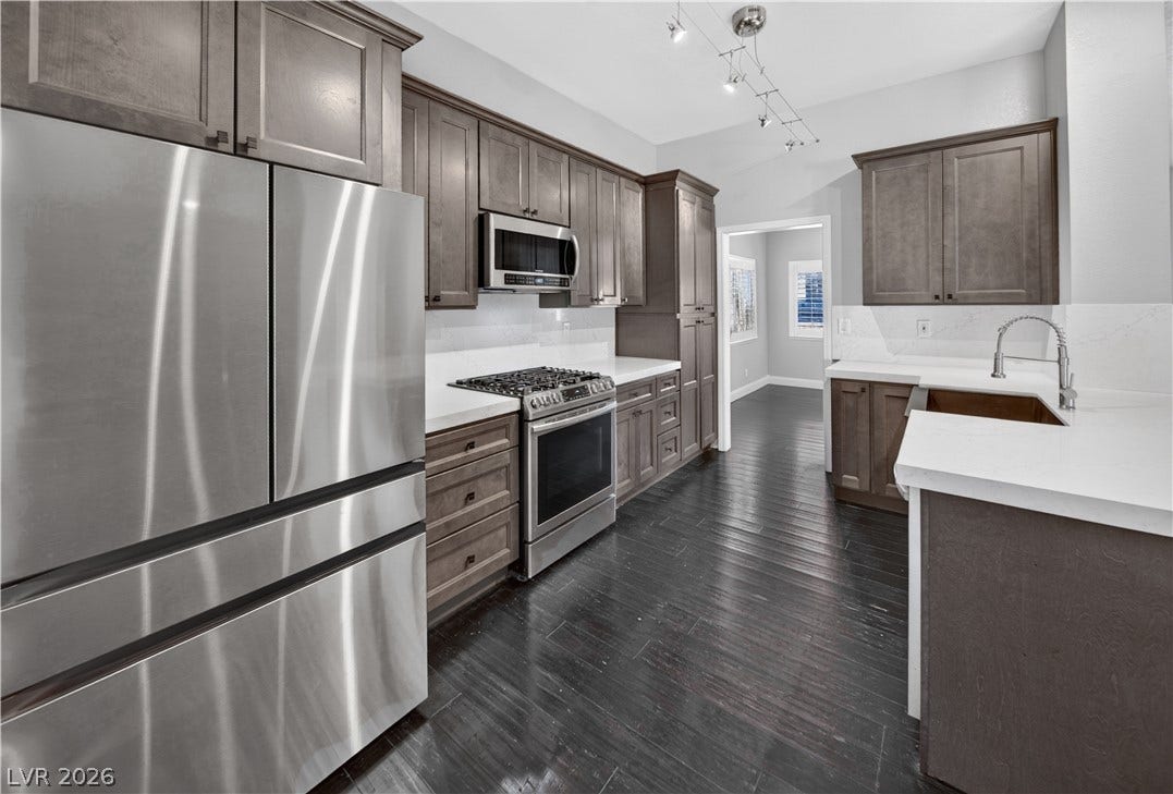 1740 Bluffs Drive, Henderson, NV 89014 Richly toned cabinetry and crisp stone countertops elevate this contemporary culinary space.