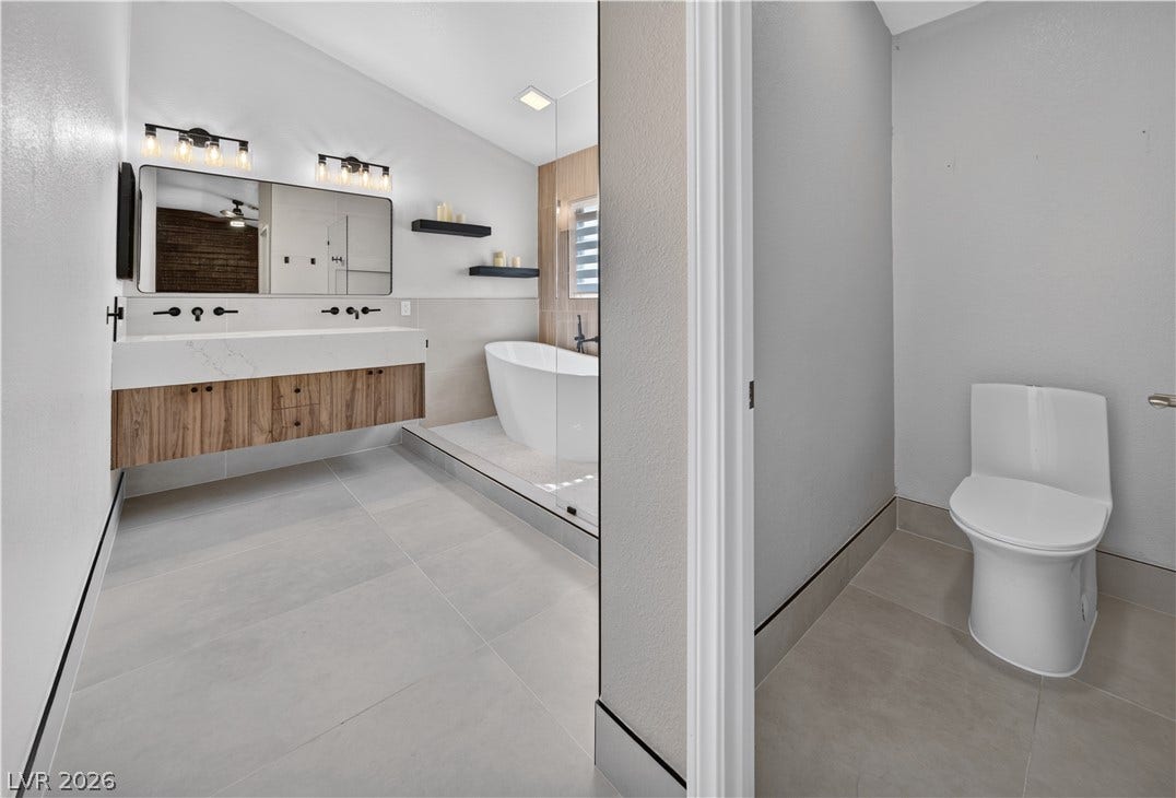 1740 Bluffs Drive, Henderson, NV 89014 A floating double vanity and freestanding soaking tub define this contemporary bath space.