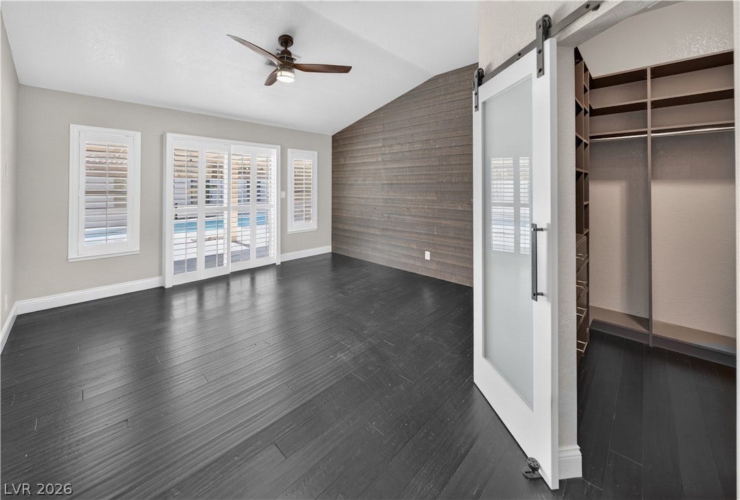 1740 Bluffs Drive, Henderson, NV 89014 Dark wood flooring and a vaulted ceiling complement the custom sliding barn door entry.