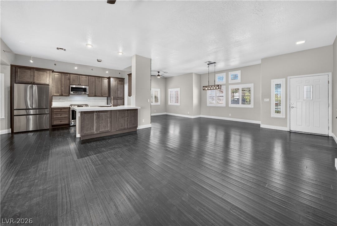 1740 Bluffs Drive, Henderson, NV 89014 Dark wood flooring anchors this open-concept layout connecting the kitchen and dining areas seamlessly.