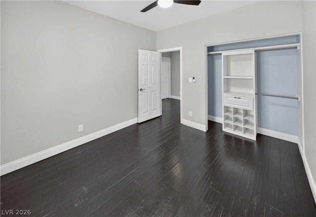 1740 Bluffs Drive, Henderson, NV 89014 Dark wood flooring and a built-in closet system elevate this versatile bedroom.