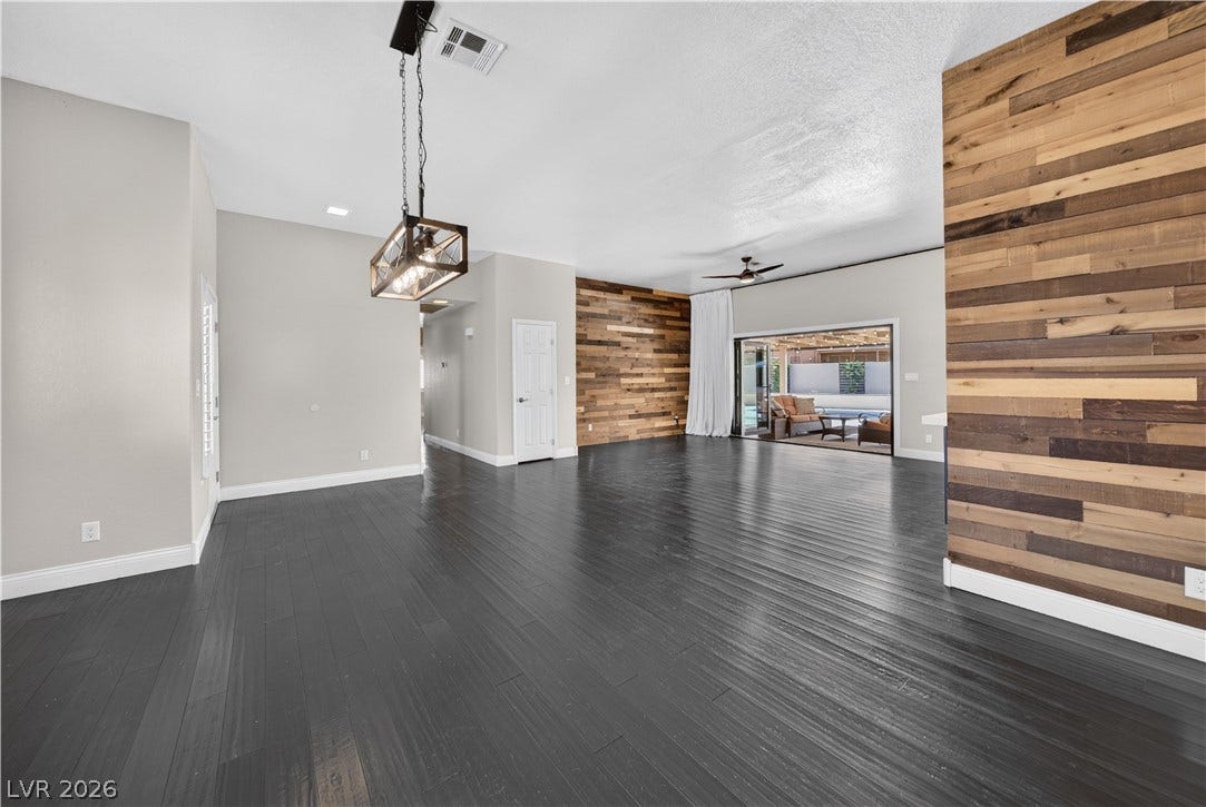 1740 Bluffs Drive, Henderson, NV 89014 Rich wood plank floors and natural wood accent walls define this versatile open living space.