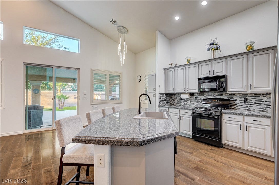 4120 Hawks Glide Avenue, North Las Vegas, NV 89084 High ceilings and a stone-topped island define this airy kitchen space.