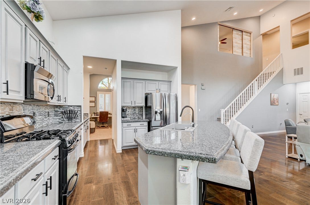 4120 Hawks Glide Avenue, North Las Vegas, NV 89084 An open kitchen boasts soaring vaulted ceilings and polished hardwood flooring throughout.