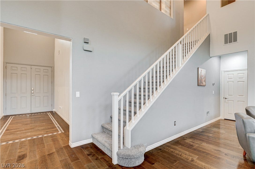 4120 Hawks Glide Avenue, North Las Vegas, NV 89084 Hardwood floors and soaring ceilings frame a carpeted staircase in this airy entry foyer.