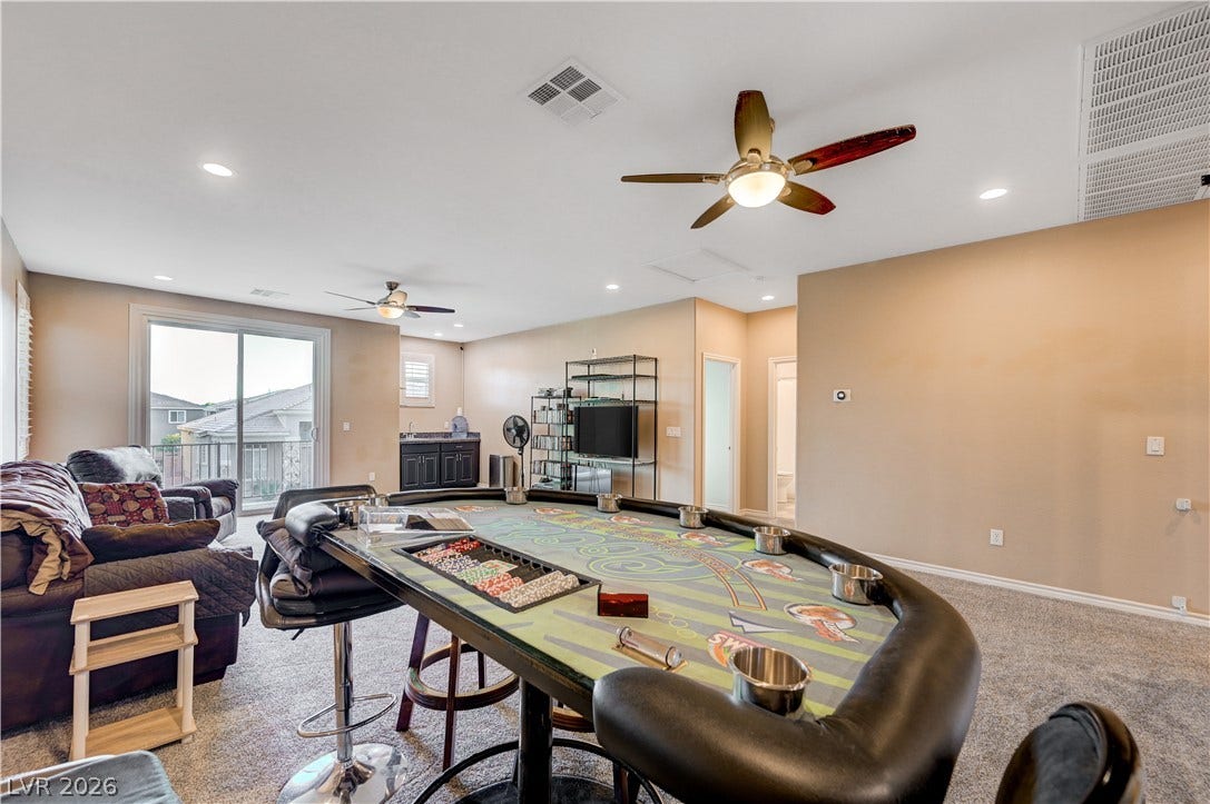 4120 Hawks Glide Avenue, North Las Vegas, NV 89084 A spacious game room features soft wall-to-wall carpeting and sliding glass doors leading outside.