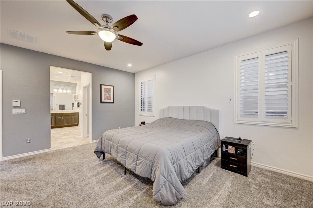 4120 Hawks Glide Avenue, North Las Vegas, NV 89084 A spacious bedroom features plush carpeting, recessed lighting, and large windows with plantation shutters.