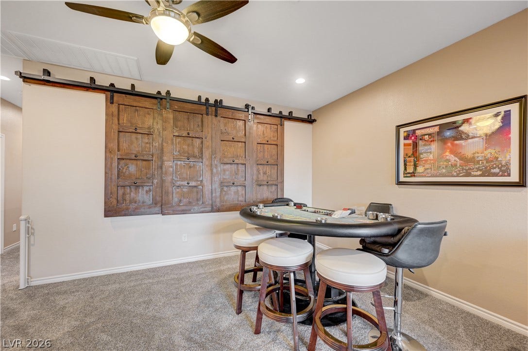 4120 Hawks Glide Avenue, North Las Vegas, NV 89084 A versatile recreation space featuring plush carpeting and unique wooden sliding barn-style shutters.