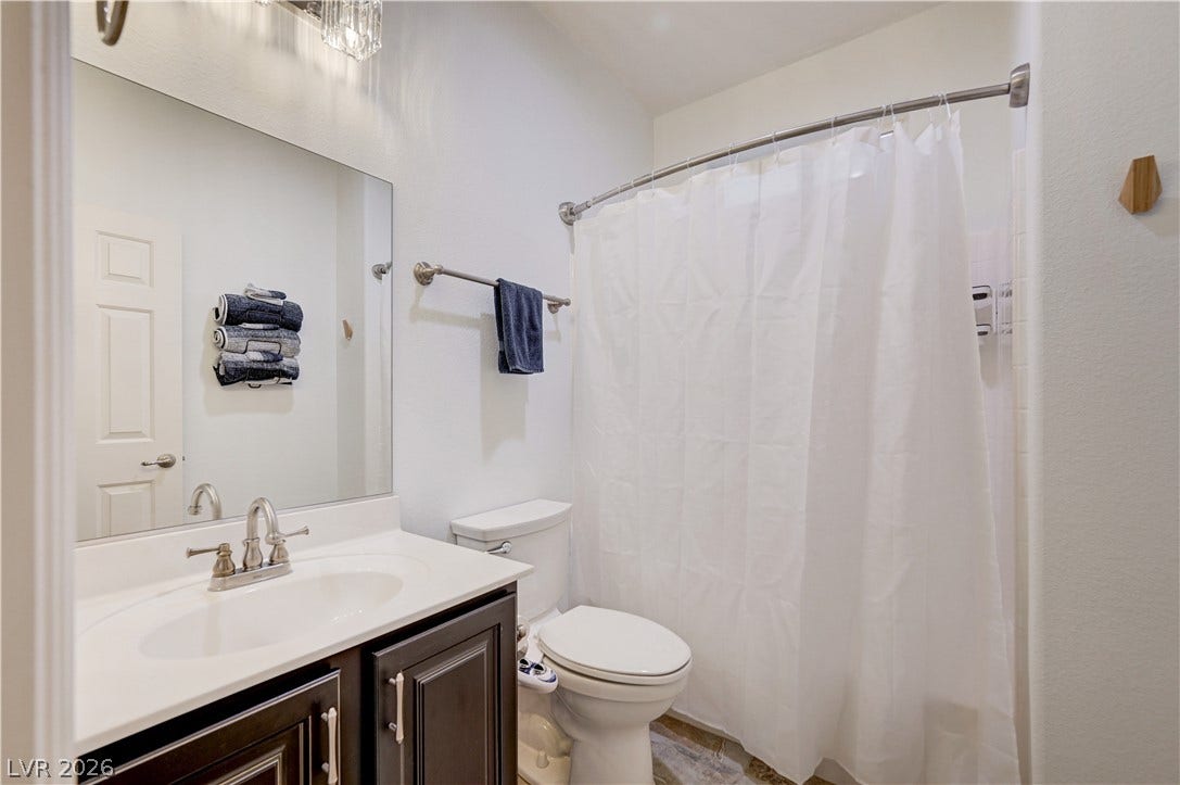 4120 Hawks Glide Avenue, North Las Vegas, NV 89084 A classic vanity with dark cabinetry sits adjacent to the shower in this full bathroom.