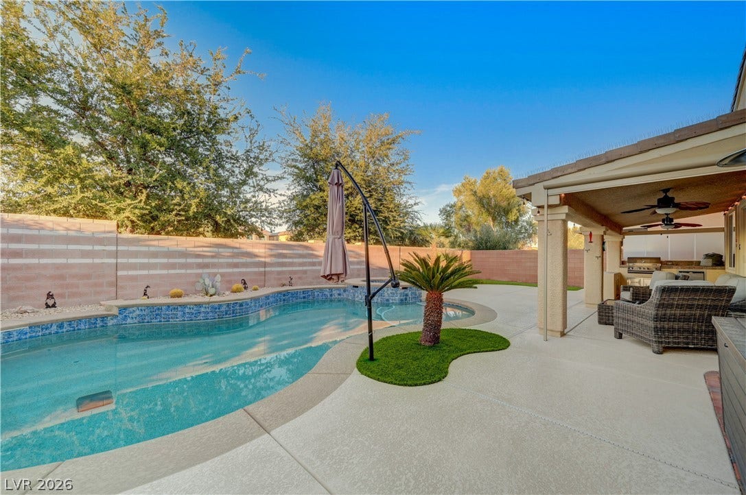 4120 Hawks Glide Avenue, North Las Vegas, NV 89084 A spacious concrete patio surrounds an inviting in-ground swimming pool alongside a covered terrace.