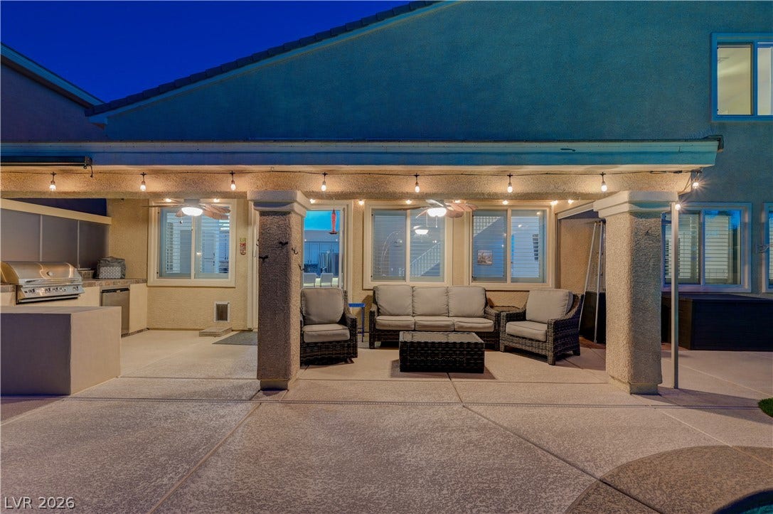 4120 Hawks Glide Avenue, North Las Vegas, NV 89084 A spacious covered patio features extensive concrete flooring and a fully integrated outdoor kitchen setup.