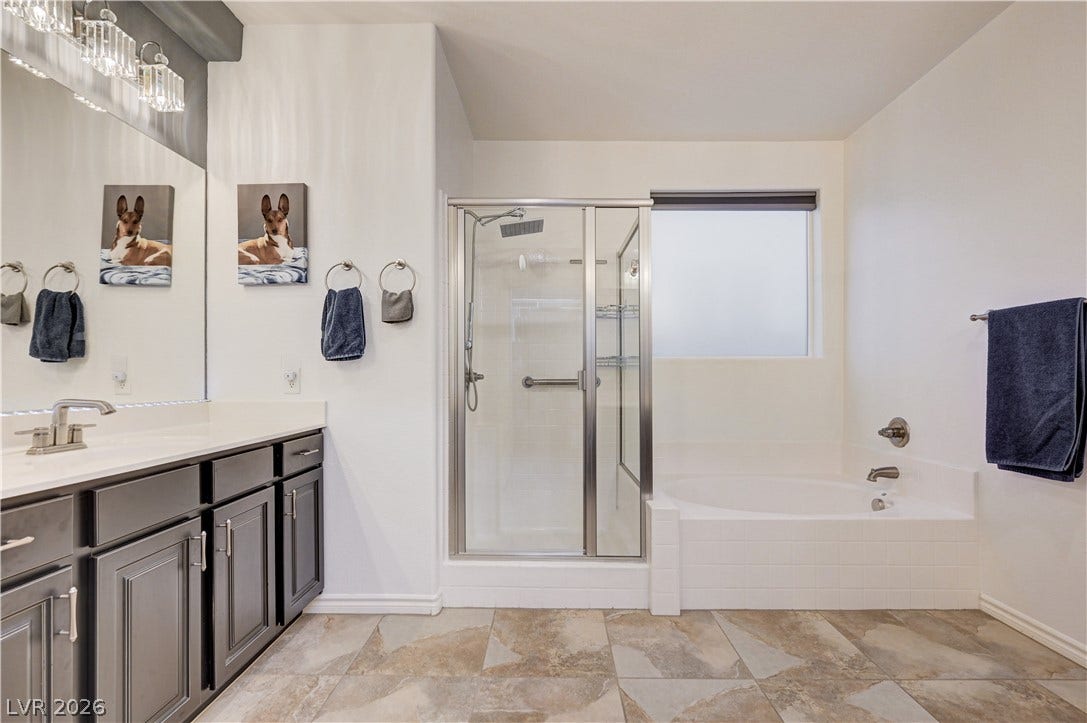 4120 Hawks Glide Avenue, North Las Vegas, NV 89084 A glass-enclosed shower stands alongside a soaking tub over tiled flooring.