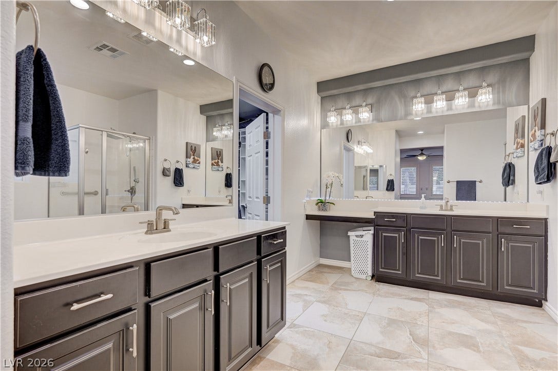 4120 Hawks Glide Avenue, North Las Vegas, NV 89084 Ample counter space and classic cabinetry define this tiled master bathroom.