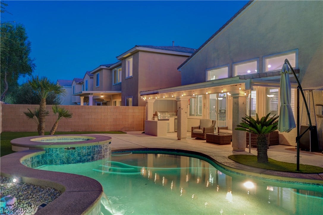 4120 Hawks Glide Avenue, North Las Vegas, NV 89084 A sparkling pool and raised spa anchor this inviting outdoor entertainment space under the evening sky.