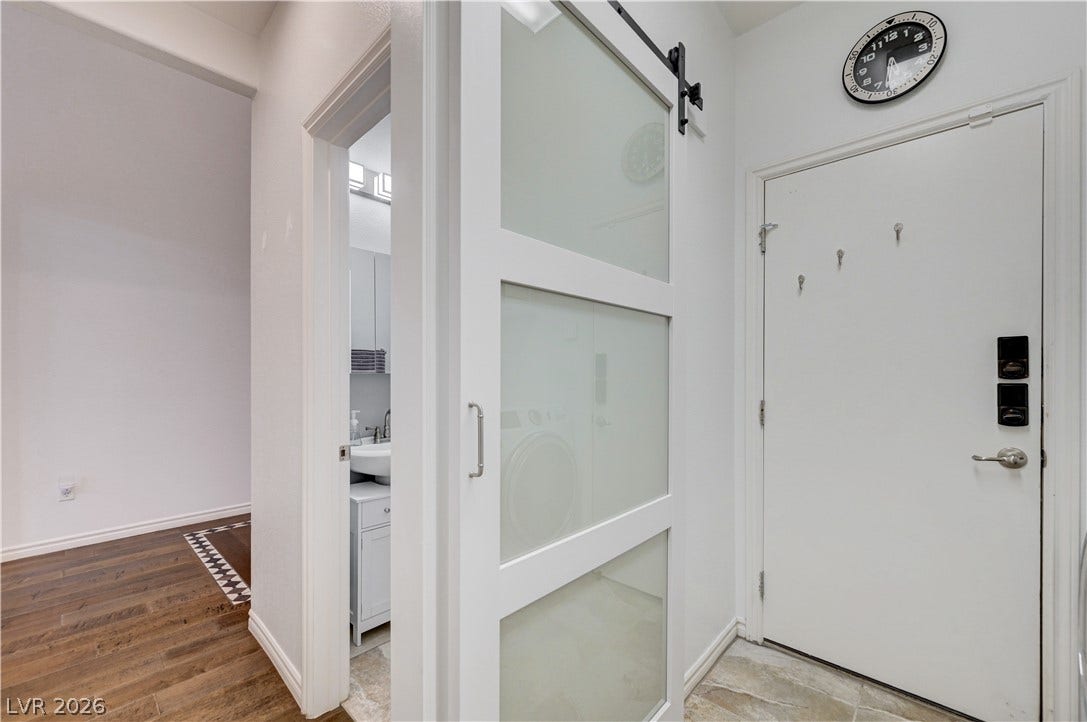 4120 Hawks Glide Avenue, North Las Vegas, NV 89084 Gleaming wood floors flow toward a modern entryway featuring a stylish frosted glass sliding door.
