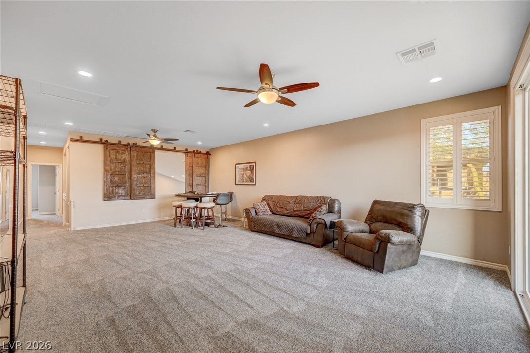 4120 Hawks Glide Avenue, North Las Vegas, NV 89084 A spacious secondary living area features wall-to-wall carpeting and sliding glass doors to the outside.