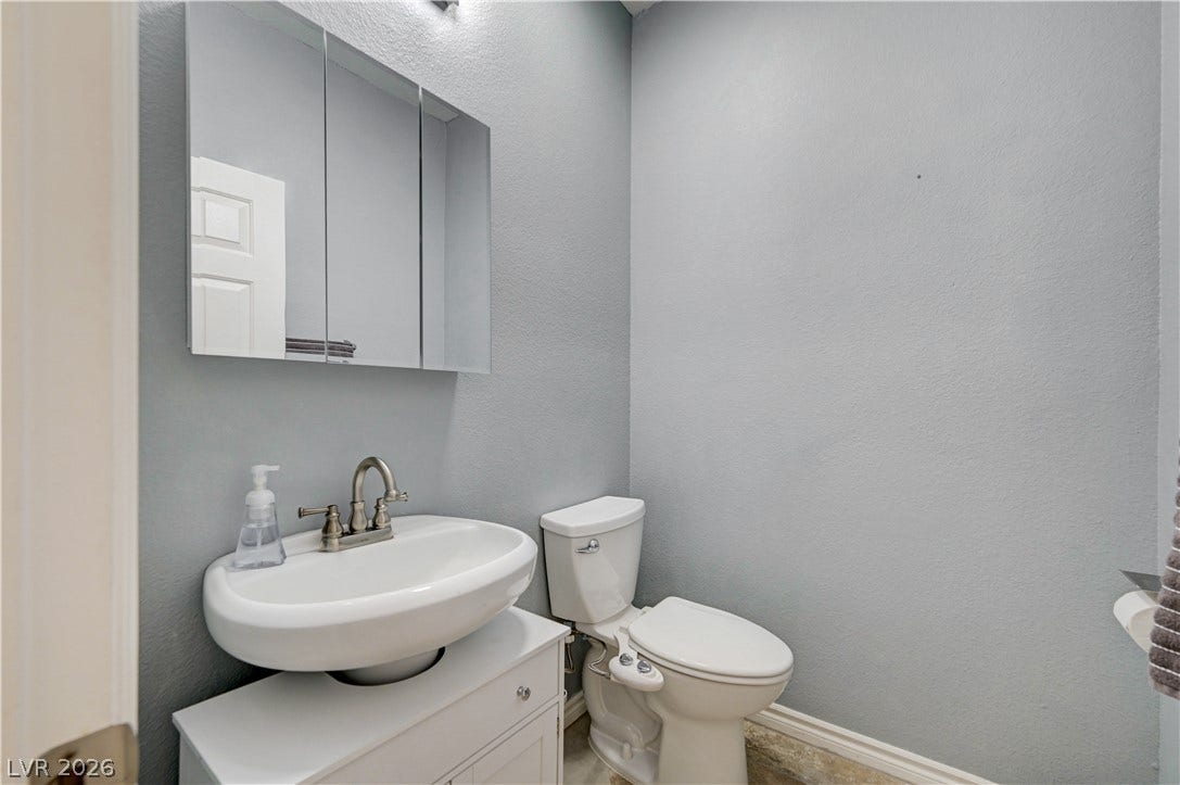 4120 Hawks Glide Avenue, North Las Vegas, NV 89084 A classic pedestal-style sink pairs with a tri-fold medicine cabinet in this functional powder room.