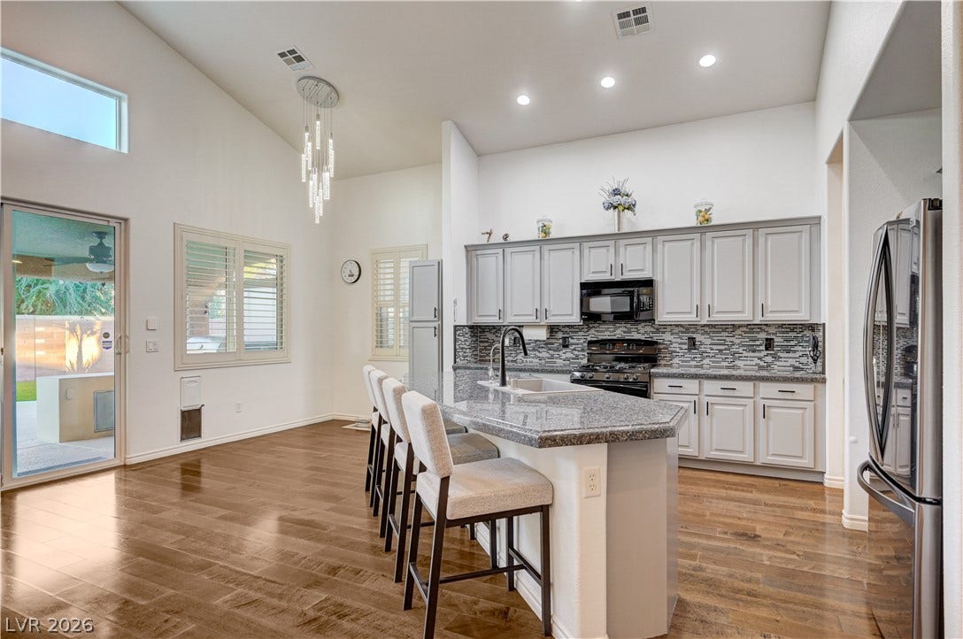 4120 Hawks Glide Avenue, North Las Vegas, NV 89084 Gleaming hardwood floors and vaulted ceilings elevate this airy kitchen design.
