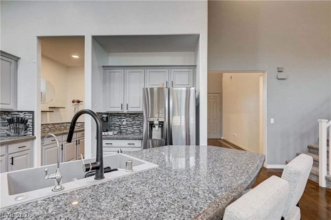 4120 Hawks Glide Avenue, North Las Vegas, NV 89084 Polished granite countertops anchor a central breakfast bar overlooking the airy living space.