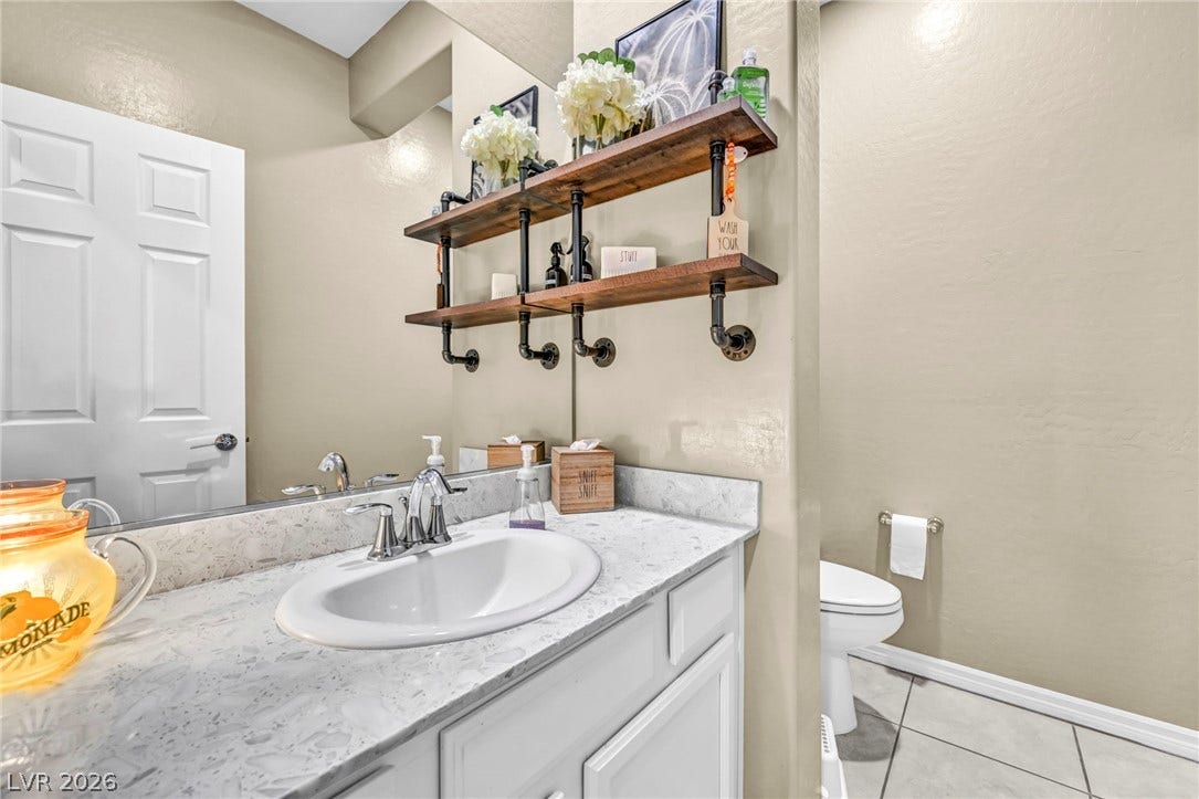 Gleaming stone countertops and ceramic tile flooring define this bright, functional bathroom layout.