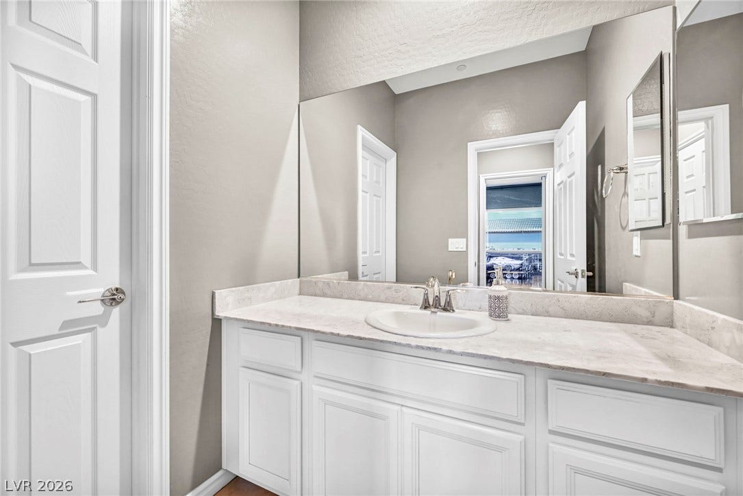 A polished stone countertop anchors the vanity in this elegantly appointed powder room.
