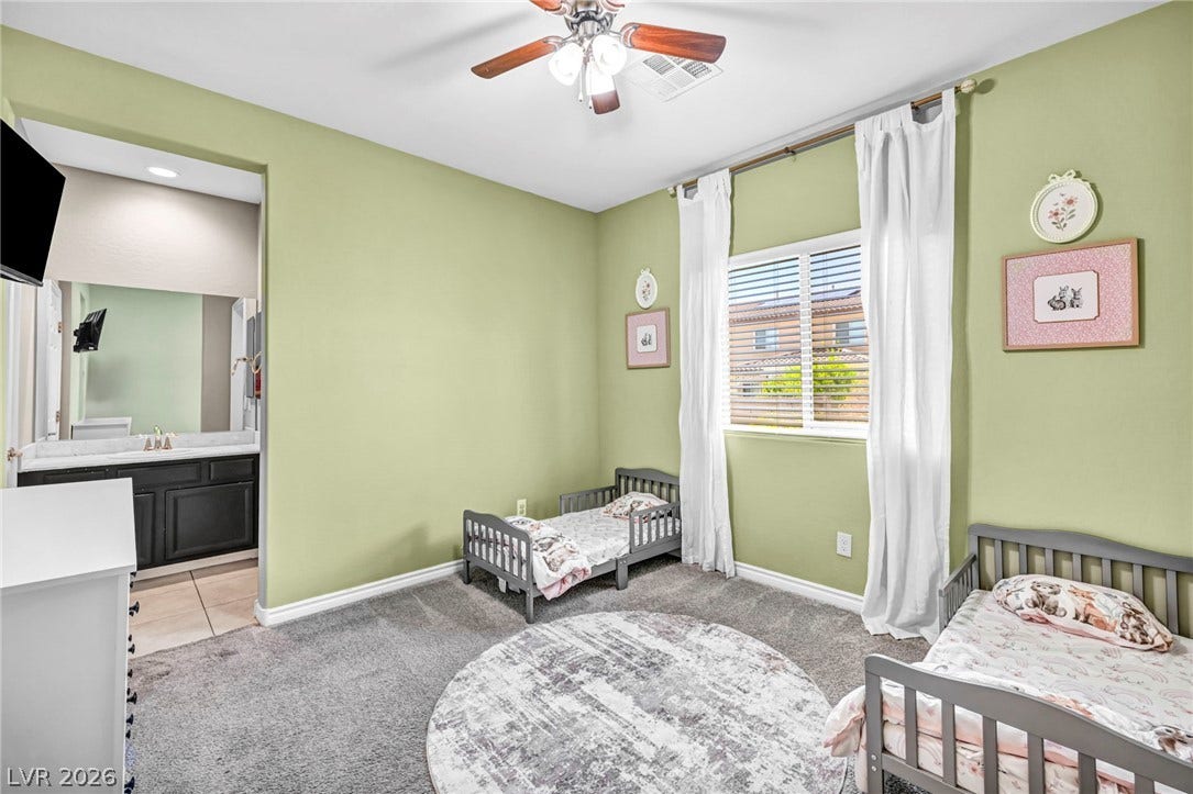 Plush carpeting underfoot and an attached vanity area complete this comfortable bedroom.