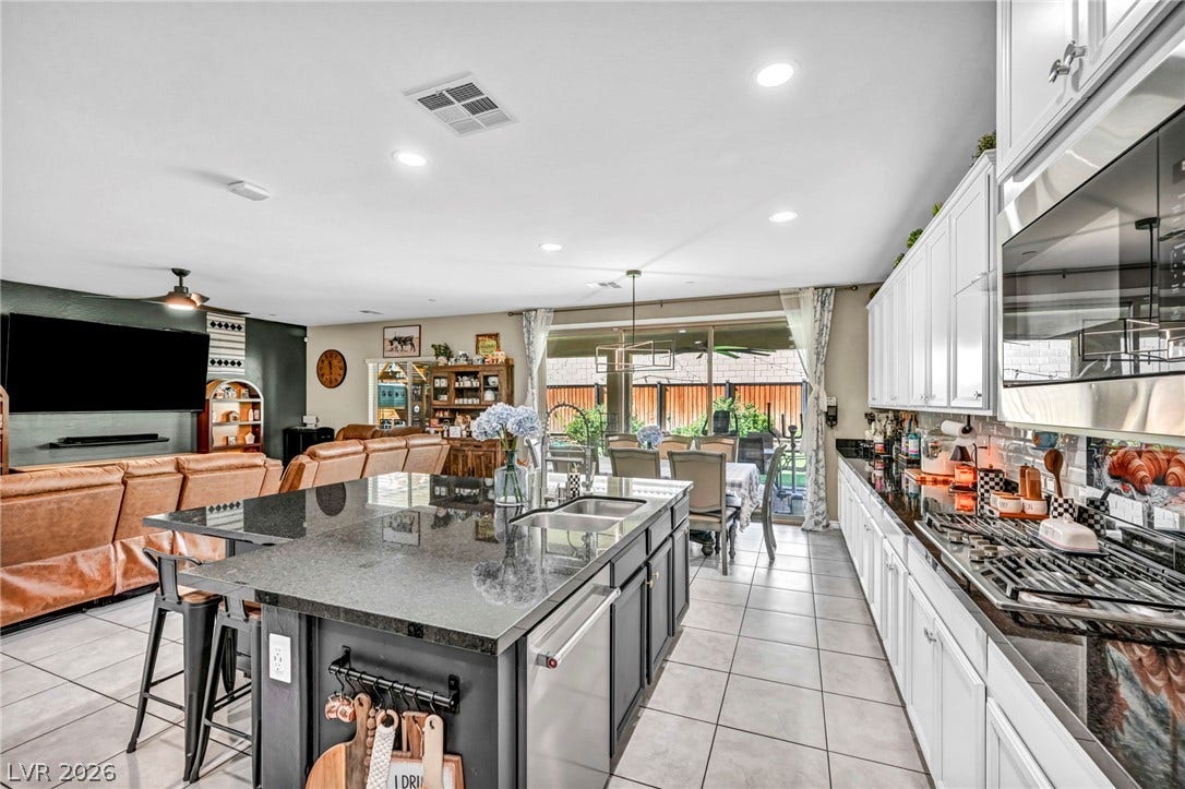 Granite countertops and crisp white cabinetry define this highly functional culinary space.