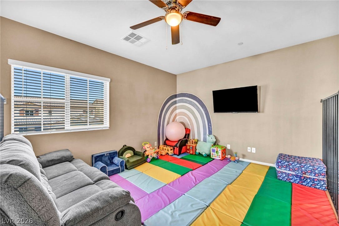 Natural light from a wide window illuminates this versatile bonus space with carpet flooring.