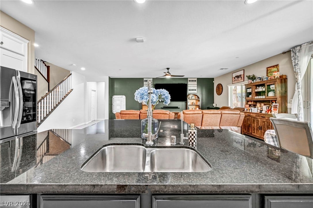 Granite countertops and an open layout connect the kitchen seamlessly to the living area.