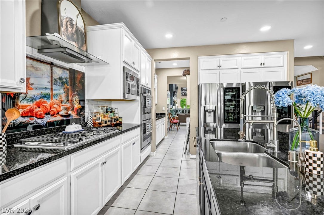 Polished granite countertops and classic tile flooring define this bright, open kitchen space.