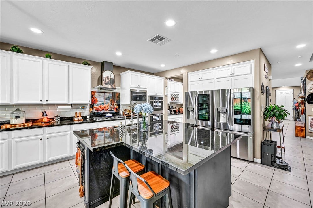 Gleaming stone countertops and a spacious central island anchor this modern culinary workspace.