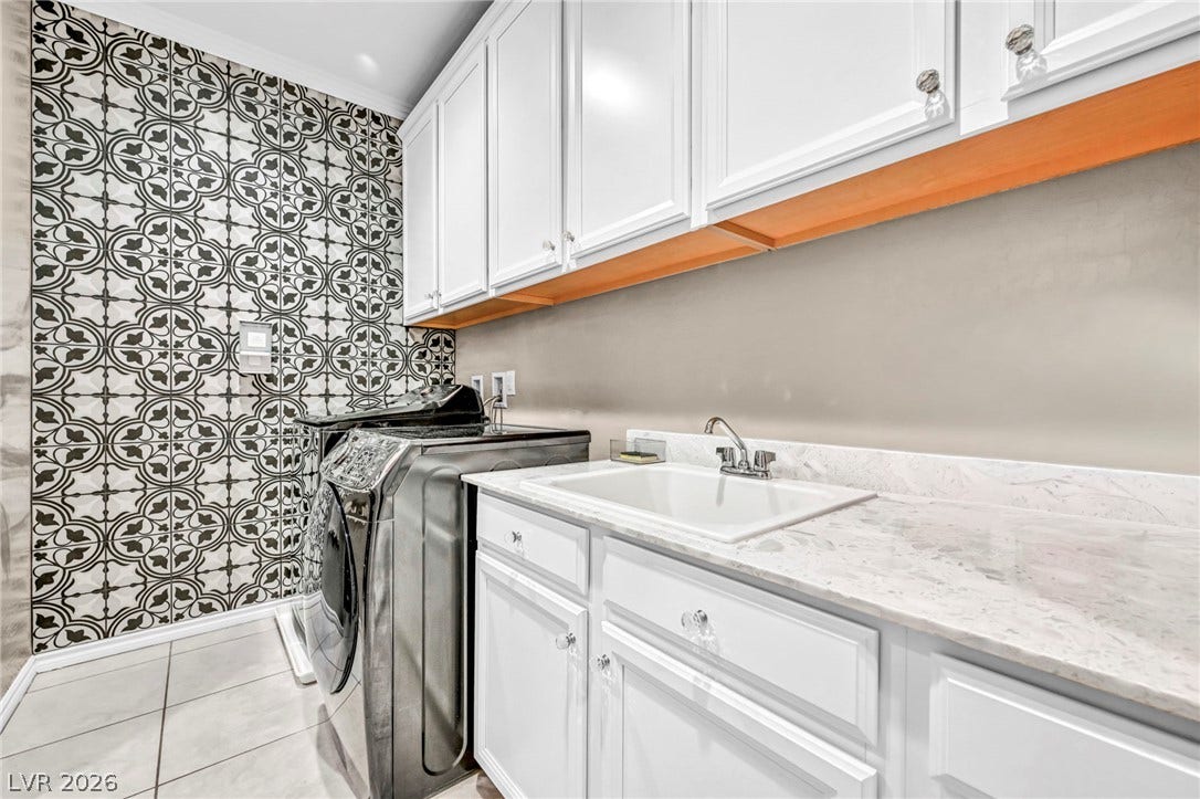 Patterned accent tile and stone countertops elevate this highly functional utility space.