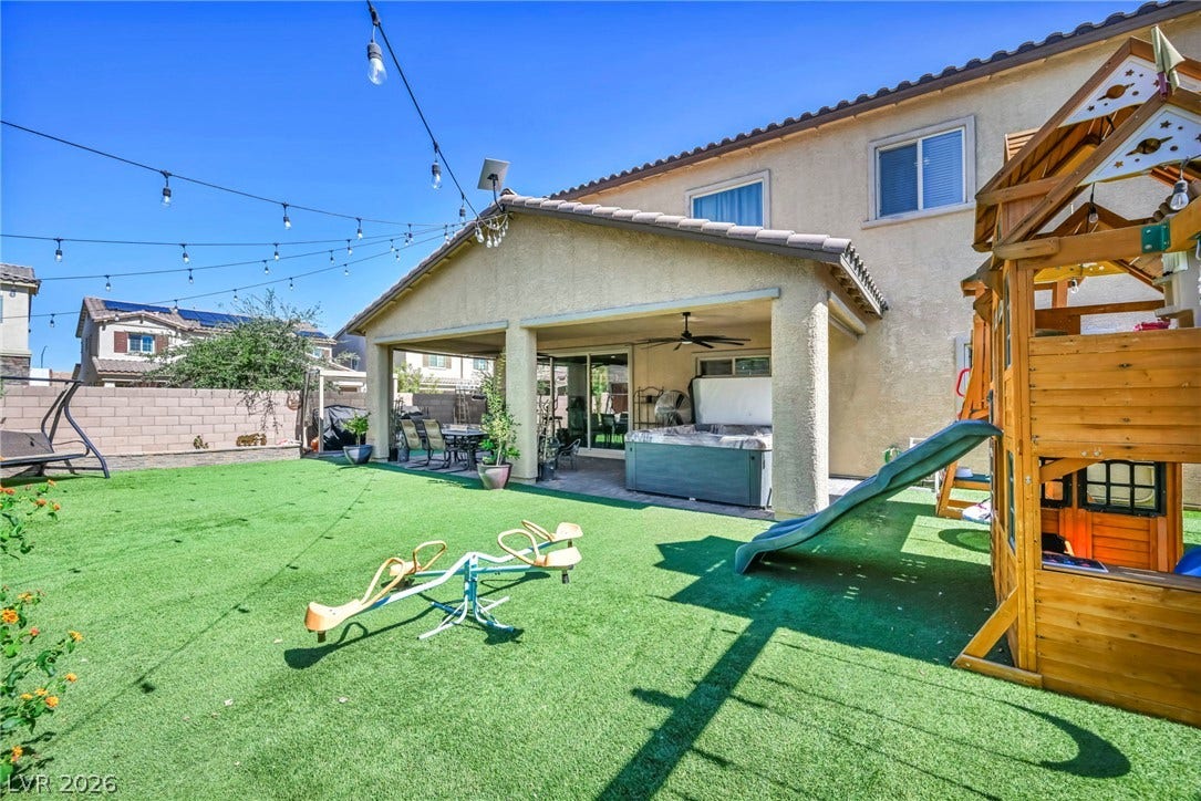 A spacious covered patio overlooks a grassy backyard ideal for outdoor recreation.