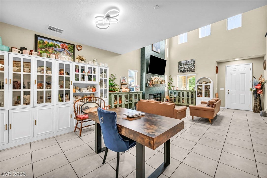 High ceilings and tiled flooring define this open-concept main living area with a built-in fireplace.