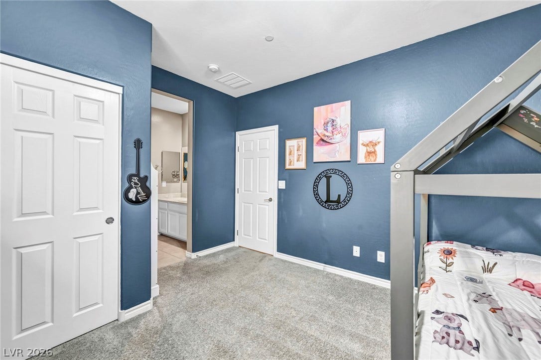Plush carpeting underfoot extends through this inviting secondary bedroom with adjacent bathroom access.