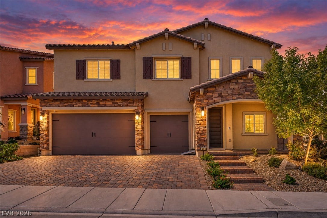 Stone accents and a paved driveway complement this two-story exterior.