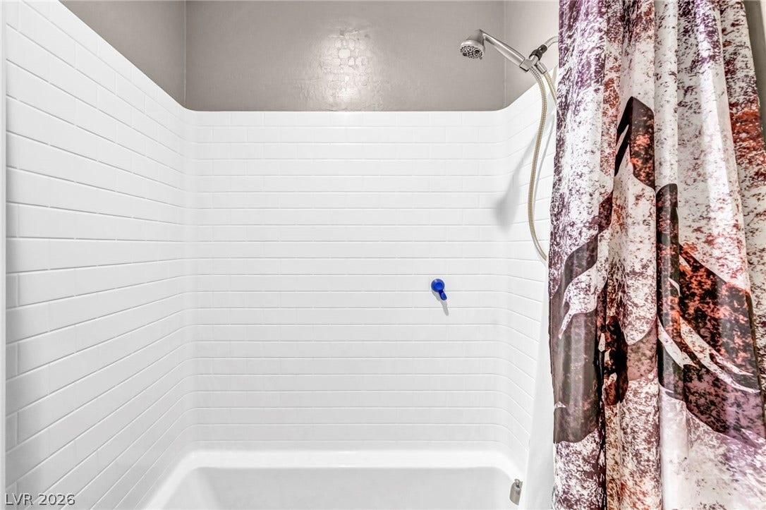 Clean subway tile surrounds this integrated tub and shower combination.