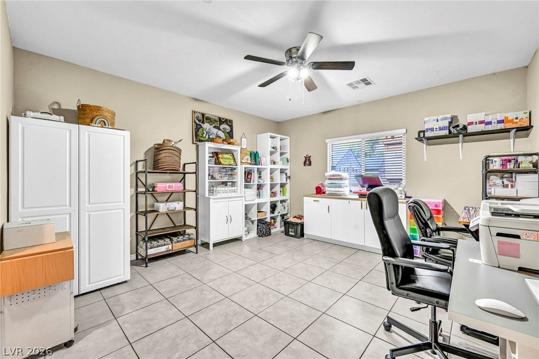 Tiled flooring and a wide window with integrated shelving create a highly functional workspace.