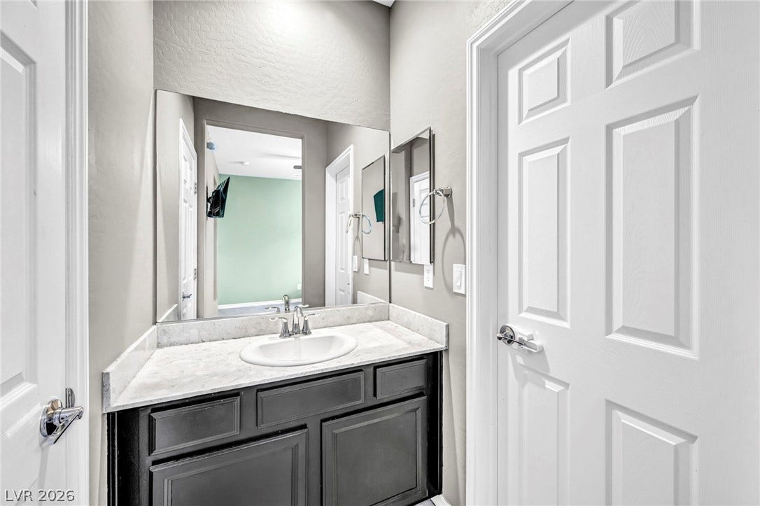 Polished stone counters elevate this functional vanity area with timeless texture.