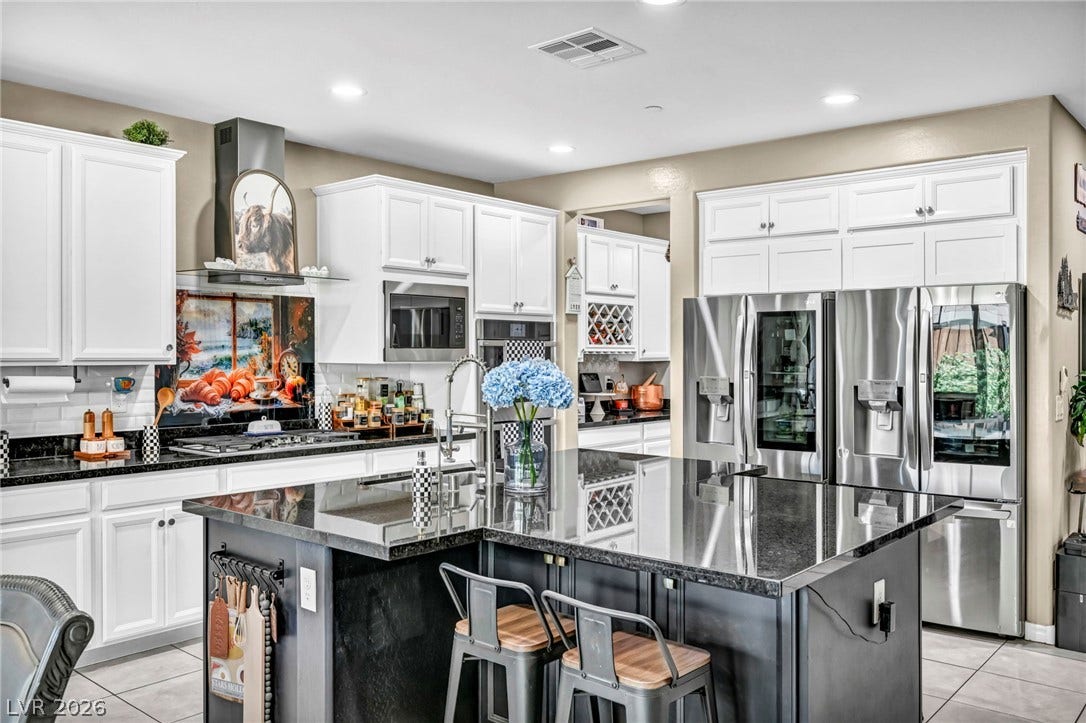 Gleaming stone countertops and stainless steel appliances anchor this modern culinary space.