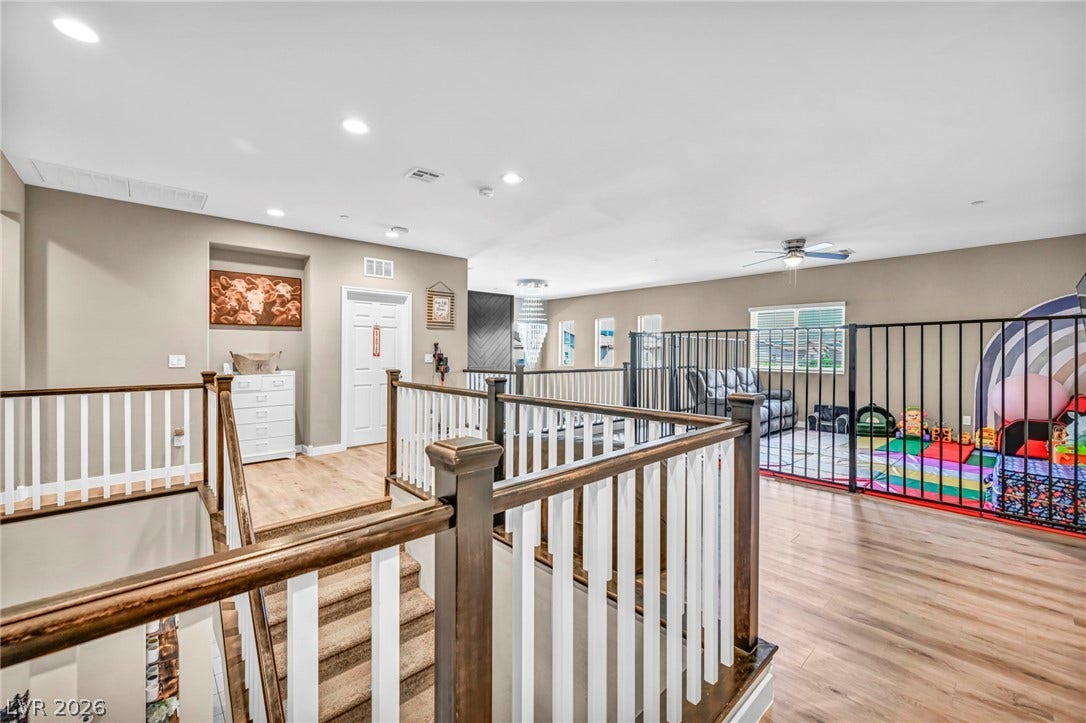 Gleaming wood flooring and classic railings define this airy upstairs landing and loft space.