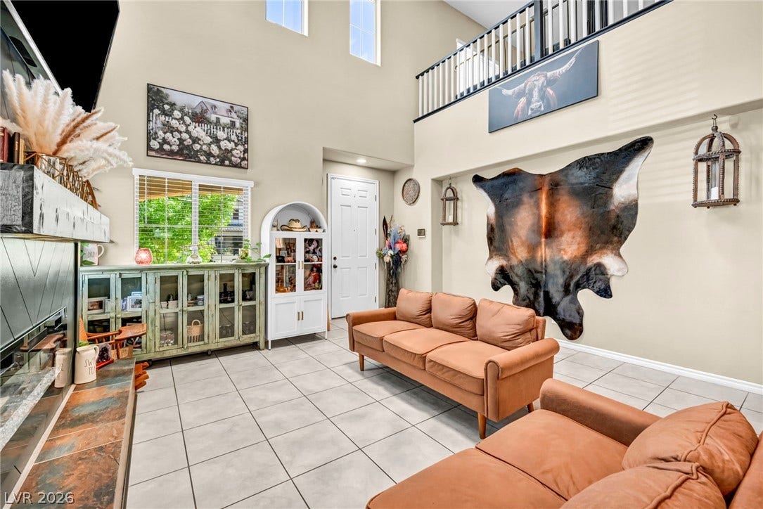 Towering ceilings and classic tile flooring define this spacious, light-filled living area.