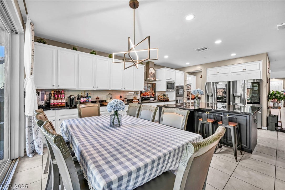 Tiled flooring and recessed lighting accent this spacious kitchen and dining area.
