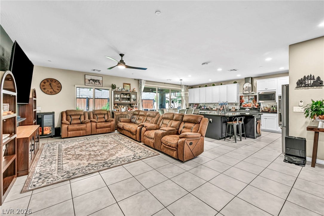 An open floor plan seamlessly connects the tiled living space to a modern kitchen.