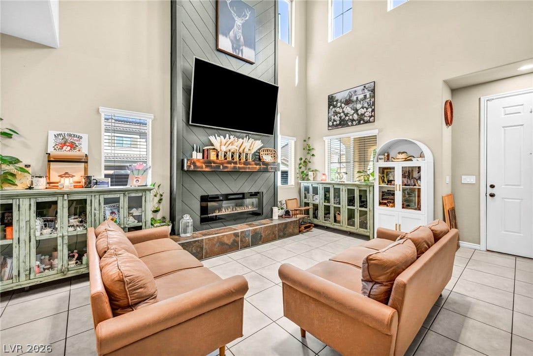 Soaring ceilings and a floor-to-ceiling fireplace anchor this light-filled main living space.
