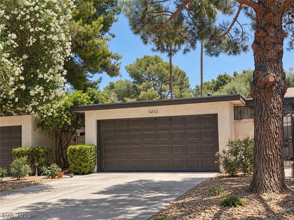 3452 Manzano Circle, Las Vegas, NV 89121 Mature trees and neat landscaping frame a spacious driveway leading to a multi-car garage.