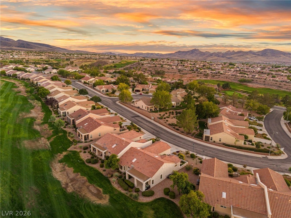 2738 Grand Forks Road, Henderson, NV 89052 Sunset skies frame this elevated neighborhood view of tile-roofed homes bordering the golf course.